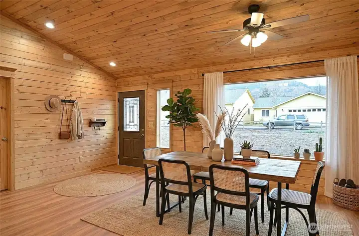 The interior features a stunning stone fireplace, framed by tongue-and-groove pine paneling, creating a warm focal point.