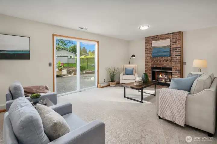 Family room with cozy wood fireplace and new carpet.