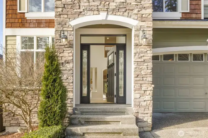 Grand Entry with rich stonework creates an impressive and inviting atmosphere.