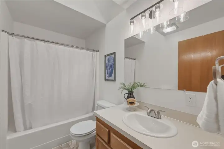 Full secondary bath with new flooring and lighting.