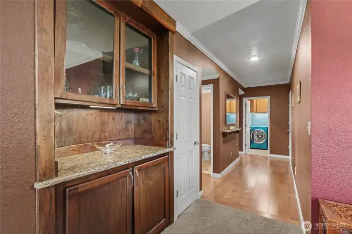 Heading down the hall from your living room, you will find this butler's pantry with granite, light above and gorgeous cabinetry, time for that post-work martini! On your left is a coat closet, then bedrooms/baths and then utility room.