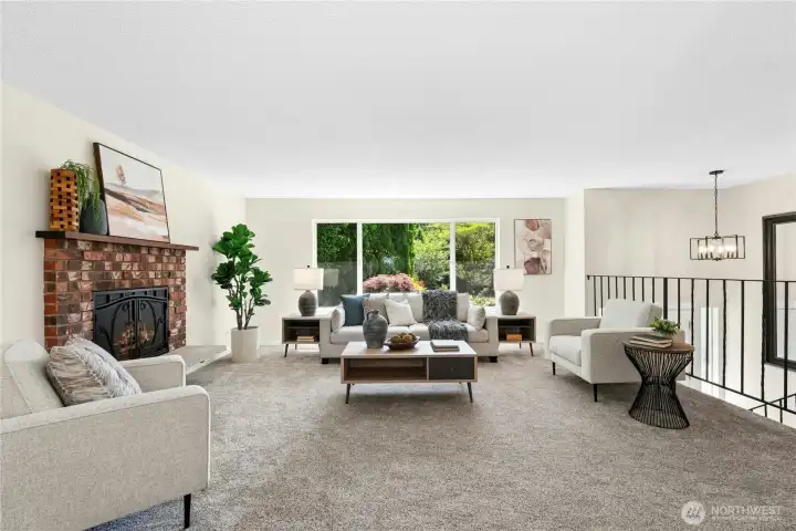 Main level living space with wood burning fireplace, large window with view of landscaping. New wall-to-wall carpeting.