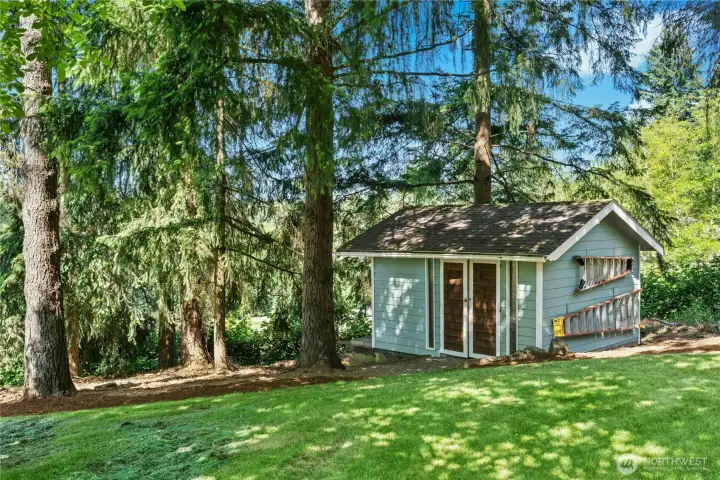 Matching shed, complete with riding lawn mower and ladders