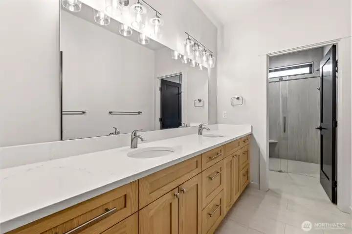 Double sink vanity with storage and mirror lighting.