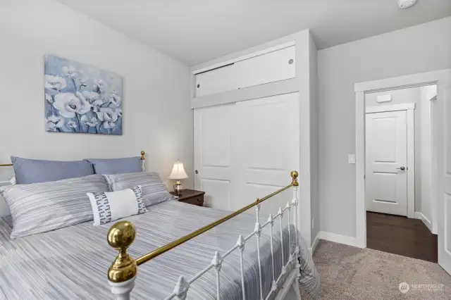 Looking across the spacious bedroom toward the full bath with the linen closet beyond.