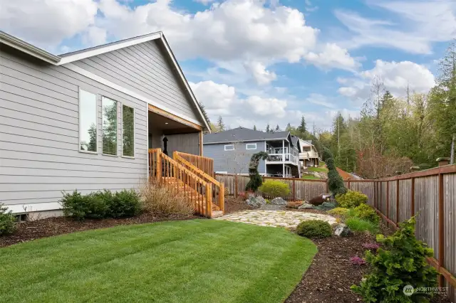 Looking across the rear yard toward the patios that are surrounded by lovely, low-maintenance landscaping.