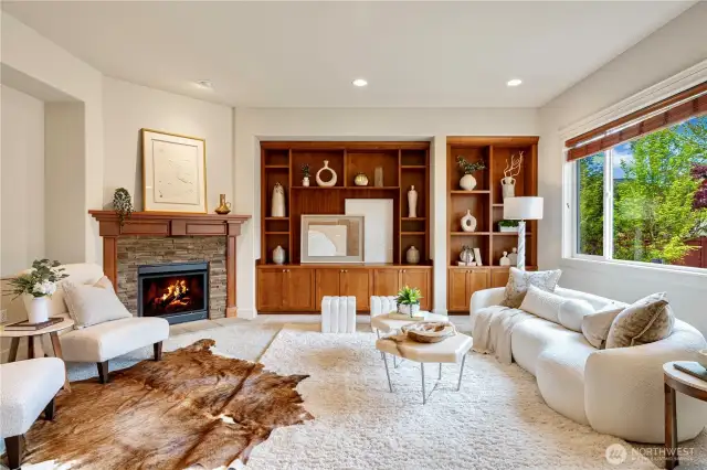 Elegant family room with custom wood built-ins, and a cozy stone fireplace.