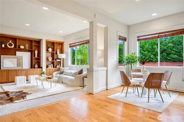 Relax in the living room with serene views through large windows overlooking the yard.