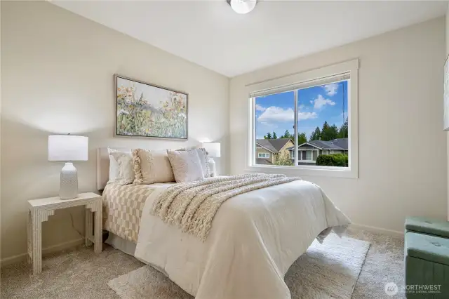 Bright 2nd bedroom with a south-facing window, allowing plenty of sunlight carpeting and a large window