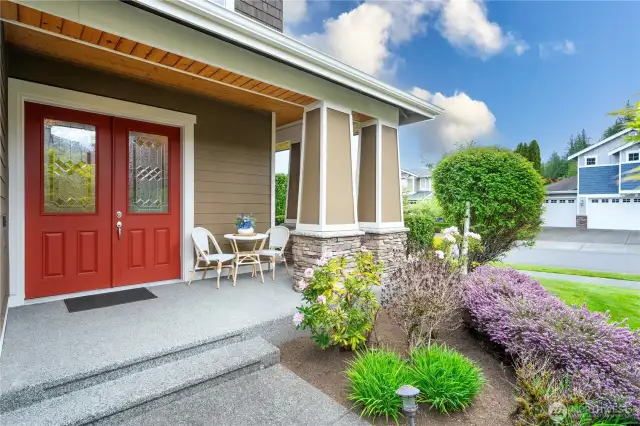 Large French doors paired with a beautifully designed porch create a warm, inviting entry.
