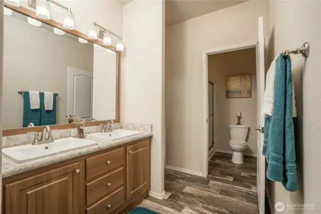 Primary bathroom with dual sinks, room for shelving. Plus water closet & shower combo for extra privacy.
