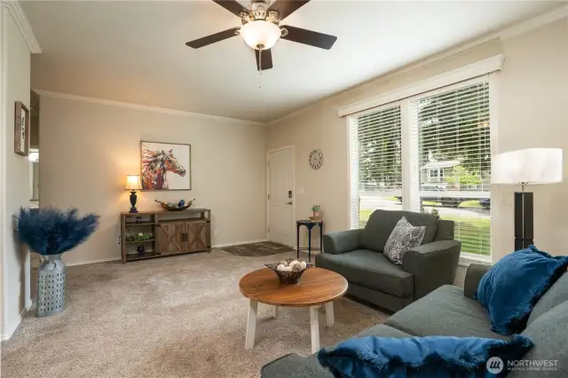 Plenty of room for you to relax in this spacious living room, plus a ceiling fan to keep nice air flow in this area, and  on the left is the hall which leads to the two additional bedrooms.