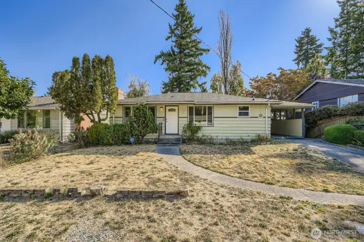 Street level approach to the south-facing front door and yard.