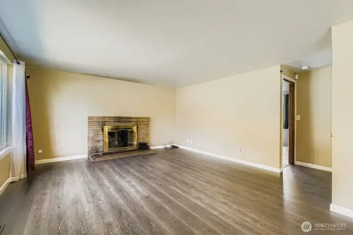 Living room with plenty of southern light and a classic wood-burning fireplace.