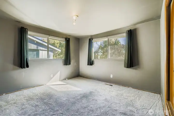 The primary bedroom on the street level at the NW corner with a built-in closet overlooking the backyard.