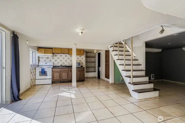 The lower level kitchen is on the north side of the house and opens via a sliding glass door to the back yard. There is a full bath on the other side of the kitchen wall and a utility room to the back right in this photo.