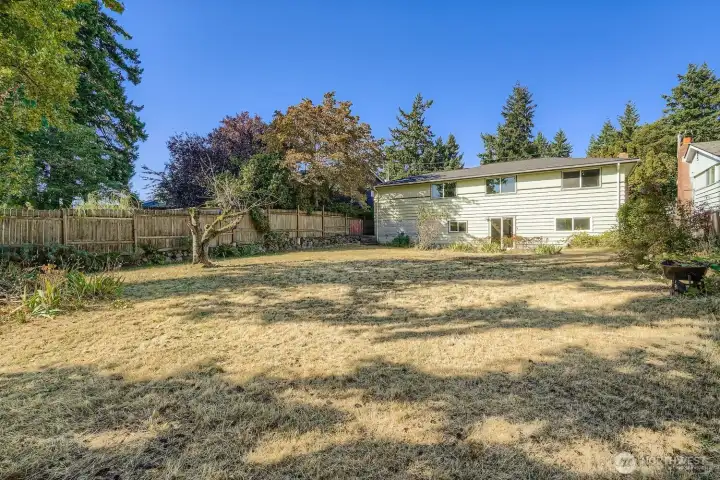 The large backyard on the north side of the house accesses the lower level of the house through the sliding glass door at the patio.
