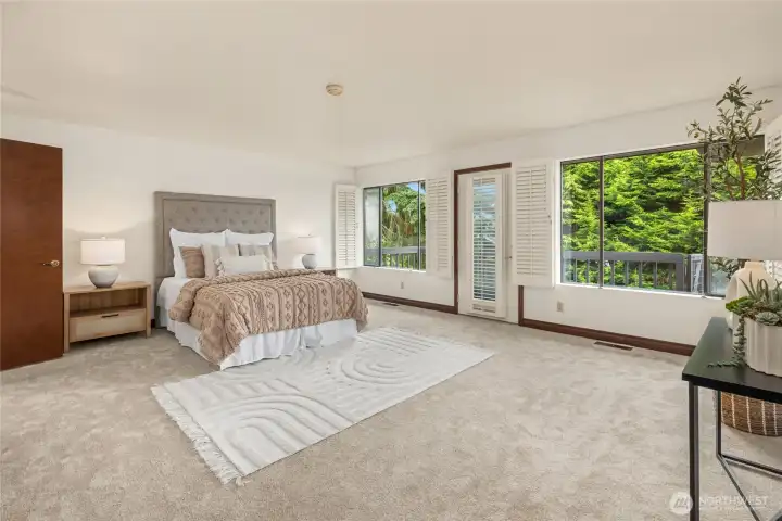The primary bedroom is enormous. The door leads to a sizable deck.