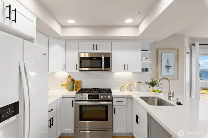 The kitchen has been updated with new quartz countertops, new shaker cabinets, new under cabinet lighting, new overhead LED lighting, and a new dishwasher.