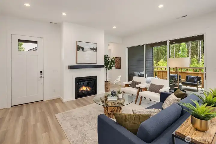 Great room with gas fireplace and multi-stack slider doors open to covered patio