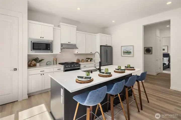 Bright kitchen with eating area on kitchen island.  Kitchen Aid refrigerator.