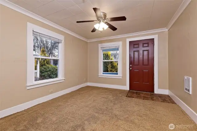 Main front entry o the living room.  Nicely trimmed, ceiling fan and window blinds.