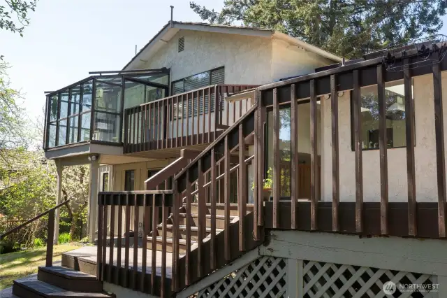 Backside of house with views of main deck, private deck and sunroom