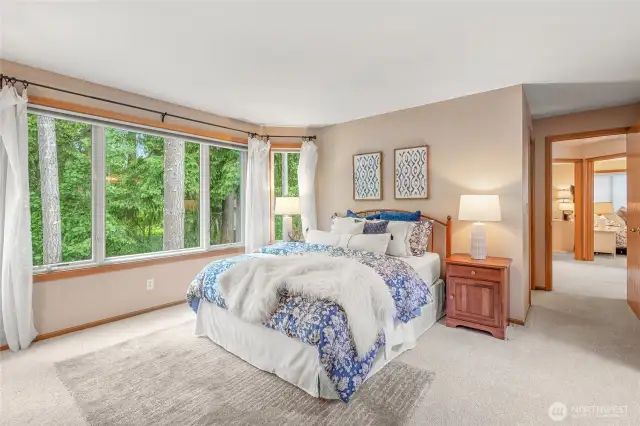 The primary suite is a peaceful oasis. It feels like you are in a forest with the beautiful mature greenery outsider the picture windows.