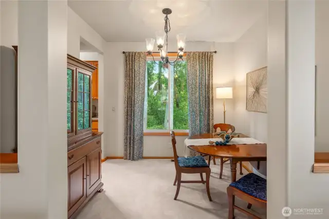 Dining room looks out to a serene green space.