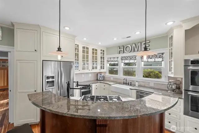 Half moon island with six burner gas range and built in pot filler makes cooking convenient and highly enjoyable.