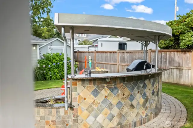 The outdoor kitchen features a two tap keg, soda stream, outdoor fridge and ice maker and a infrared lynx grill.
