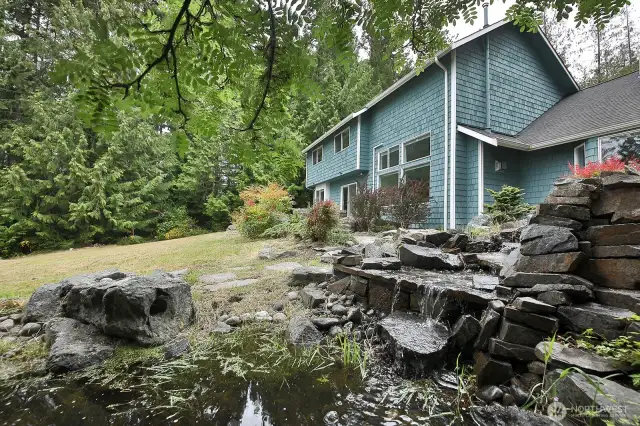 Relax to the sounds of the water feature which is also home to a few resident frogs. There is a magical cedar grove to the left edge of this photo.  Take your time to see how much land there is here to explore.