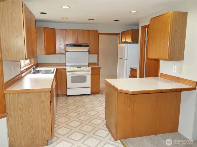 Kitchen w/ eating bar and walk-in pantry/laundry room.