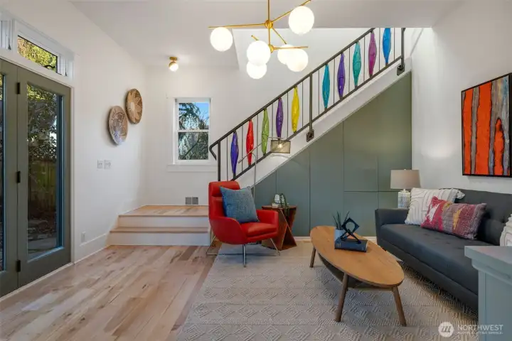 Just refinished, beautiful maple floods. Metal storage on the stairwell and a colorful detailed, metal handrail.