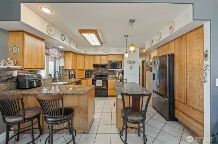 Spacious kitchen with granite counters, custom cabinets and backsplash