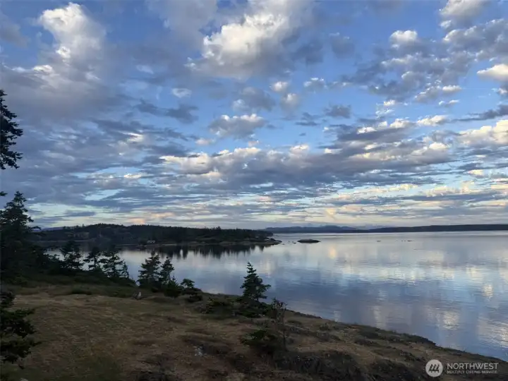 Expansive water views under dramatic Northwest skies highlight the property's breathtaking setting and connection to nature.