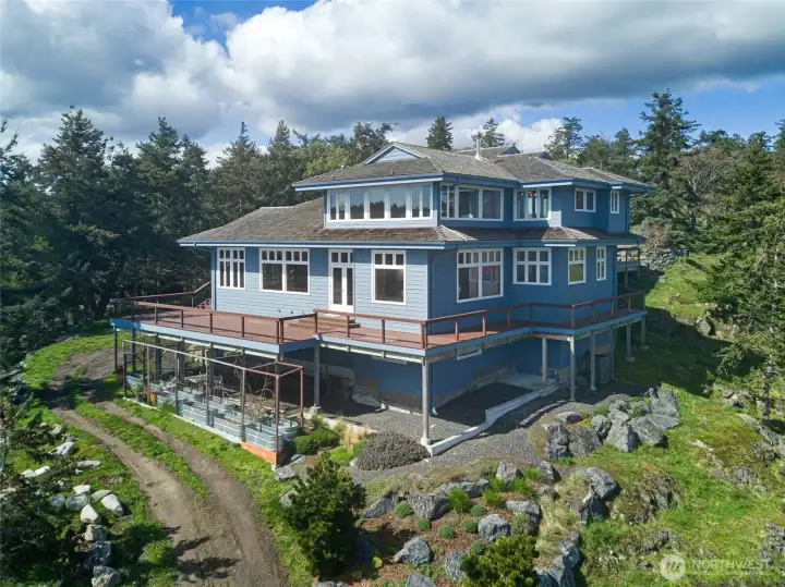 Walls of glass and generous decking frame breathtaking water views, while thoughtfully designed garden spaces enhance the home’s connection to the landscape.