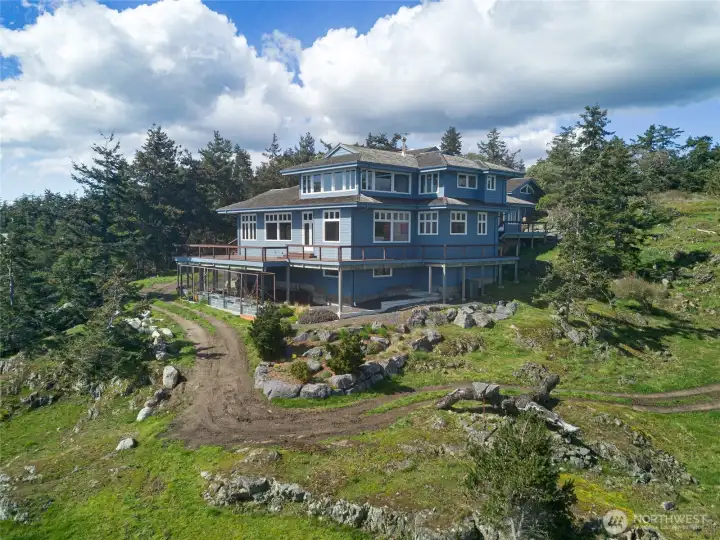 Architecturally designed coastal home with expansive wraparound decking, perfectly sited to maximize light, views, and seamless indoor-outdoor living.