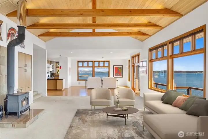 Dramatic great room with vaulted ceilings, exposed wood beams, and walls of glass capturing sweeping water views, designed for both grand entertaining and relaxed coastal living.