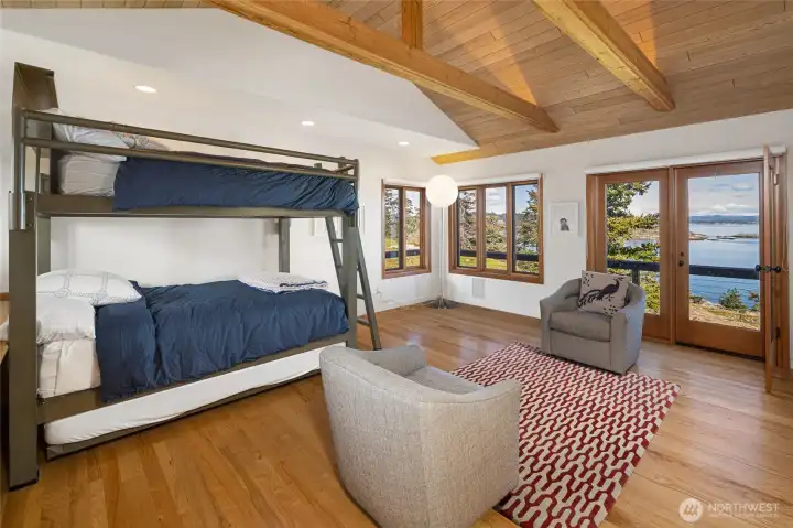 Light-filled guest retreat with vaulted ceilings, flexible sleeping space, and direct access to outdoor living, all complemented by serene waterfront views.