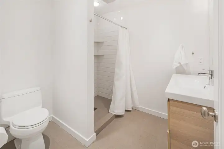 Updated bath with clean, modern finishes and walk-in shower, providing a fresh and functional space for guests or lower-level living.