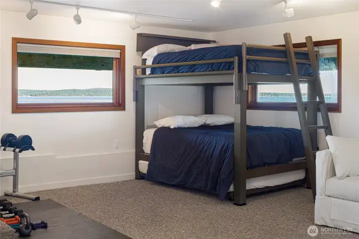 Expansive lower-level flex space ideal for guests, recreation, or wellness, featuring bunk accommodations and room for a home gym or media area.