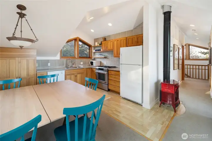 Open kitchen and dining area with warm wood cabinetry and casual seating, designed for easy everyday living and effortless entertaining in detached guest apartment.