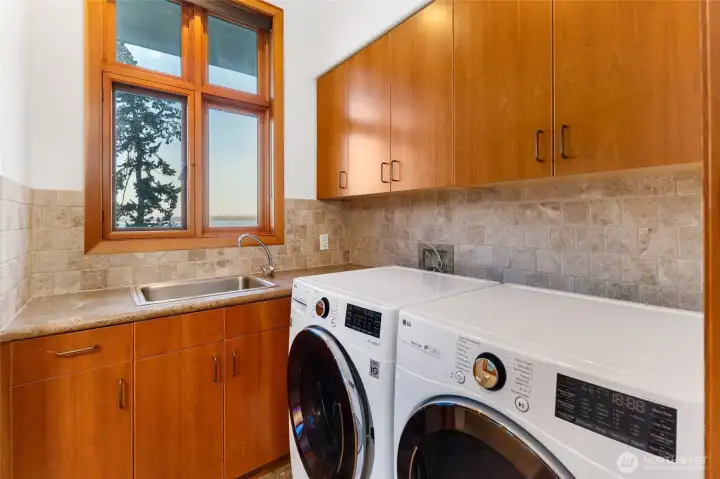 Well-designed laundry room with ample cabinetry, utility sink, and workspace—bringing both function and organization to daily living.