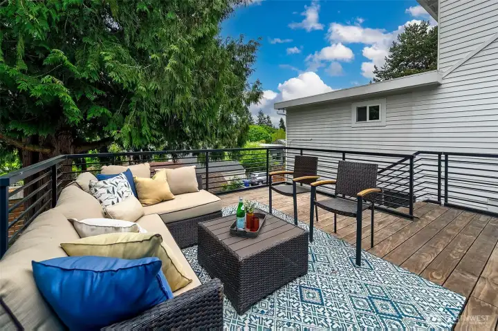 This beautiful, new 'sleeper' deck creates a waterproof patio underneath and the giant cedar tree in the backyard looks generational.