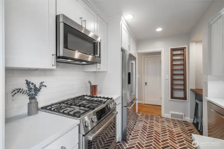 Gas cooktop and design features highlighted in this sweet kitchen.