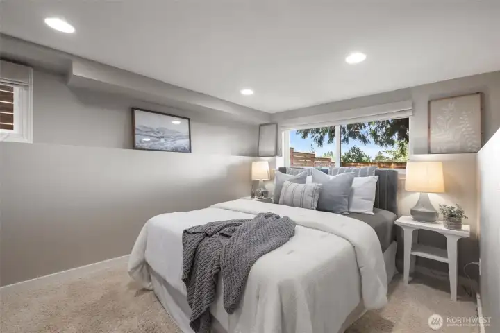 Lower level bedroom with high ceilings and lots of light with big windows.