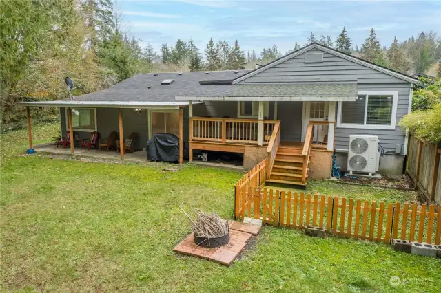 Back of home with fenced dog run area off primary bedroom deck