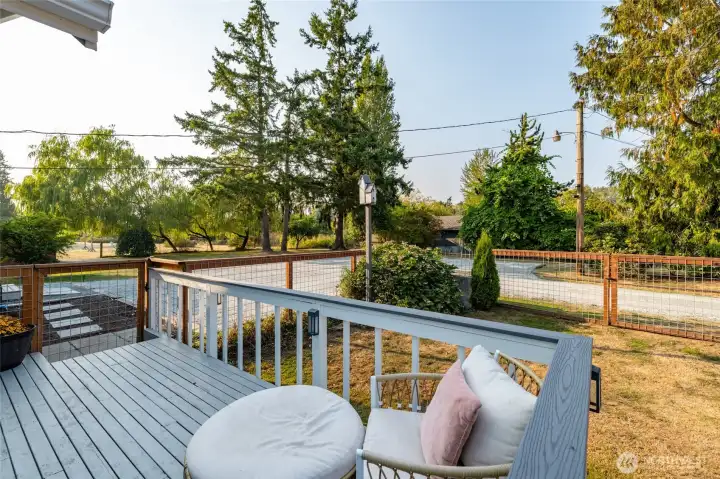 Front porch is surrounded by a completely fenced area to keep your loved ones and pets safe. There is also a large older barn/shop just visible in the background.