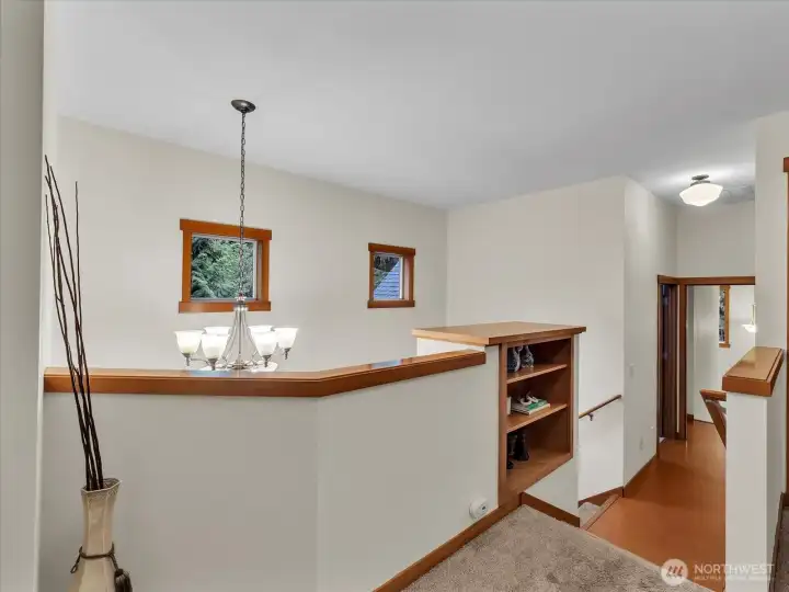 Upstairs stairway landing with built-in bookshelf. Cork flooring in this picture leads to the laundry room and bonus room and back stairs to the second kitchen.